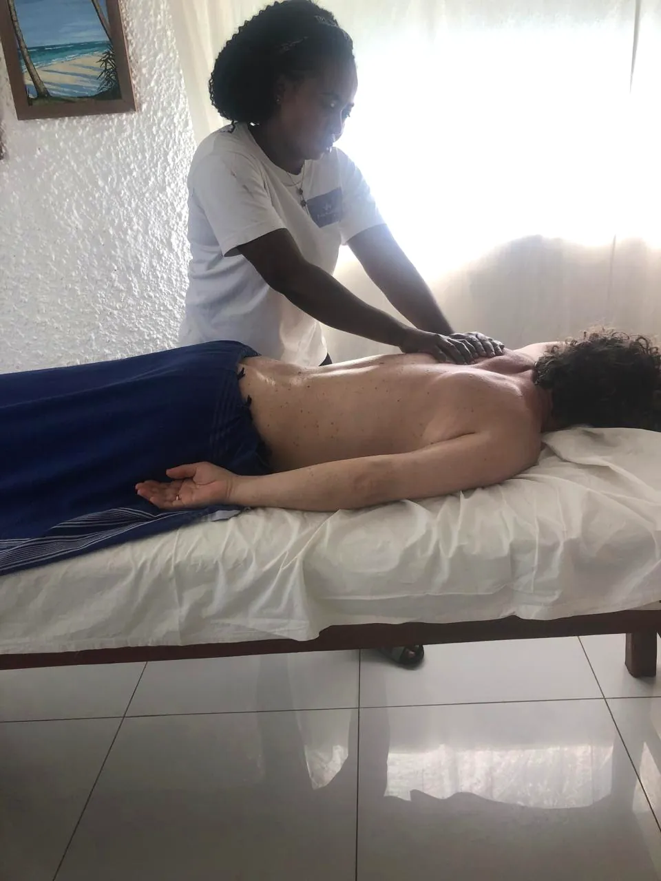 Professional massage therapist providing a treatment in Diani